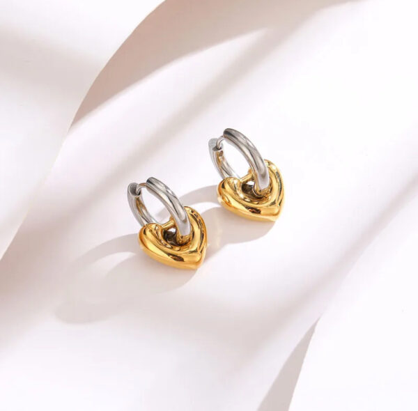 Aretes de corazón bicolor huggies acero inoxidable.